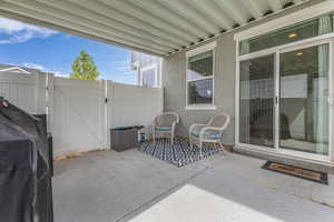 View of patio with a gate and fence