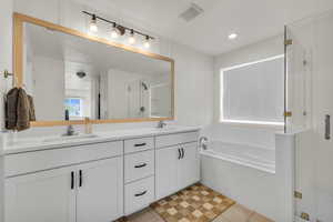 Full bath featuring a bath, a shower stall, visible vents, and a sink