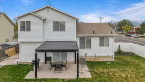 Back of property with a yard, a patio area, a mountain view, and a fenced backyard