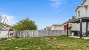 View of yard with an outdoor fire pit, a patio area, central AC unit, and fence private yard
