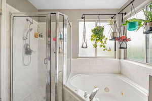 Bathroom featuring a whirlpool tub and a stall shower