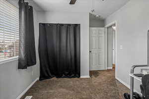 Interior space featuring baseboards, ceiling fan, and a textured ceiling