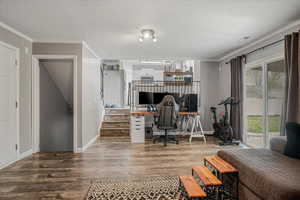 Office area with baseboards, wood finished floors, and a textured ceiling