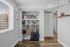 Walk in closet featuring visible vents and wood finished floors