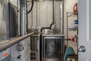 Clothes washing area featuring separate washer and dryer and laundry area