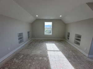 Additional living space featuring lofted ceiling, built in features, and baseboards