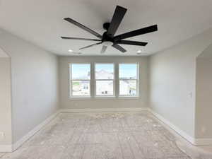 Empty room with a ceiling fan and baseboards