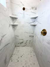Bathroom featuring a marble finish shower