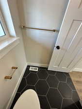 Bathroom featuring baseboards, visible vents, and toilet