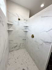 Bathroom with recessed lighting and a marble finish shower