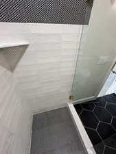 Bathroom featuring tile patterned flooring and a shower stall