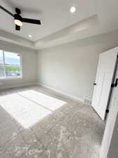 Spare room with baseboards, recessed lighting, a raised ceiling, and ceiling fan