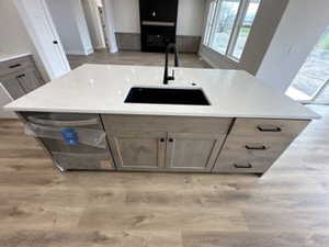 Kitchen featuring open floor plan, light wood-style flooring, and a sink