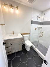 Bathroom featuring tile patterned flooring, toilet, vanity, visible vents, and a stall shower