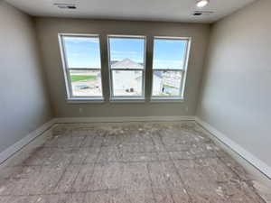 Unfurnished room featuring visible vents and baseboards