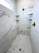 Bathroom with a marble finish shower
