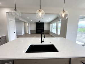 Kitchen with light stone counters, open floor plan, a healthy amount of sunlight, and a sink