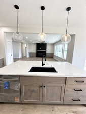 Kitchen featuring stainless steel dishwasher, a sink, decorative light fixtures, and open floor plan