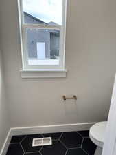 Bathroom featuring visible vents, plenty of natural light, and baseboards