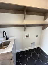 Clothes washing area featuring a sink, electric dryer hookup, hookup for a washing machine, dark tile patterned flooring, and laundry area