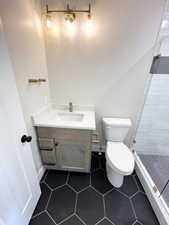 Full bathroom with tile patterned floors, a shower stall, toilet, vanity, and baseboards