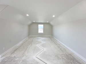 Additional living space with baseboards, recessed lighting, and vaulted ceiling