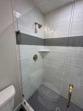 Full bath with toilet and a stall shower