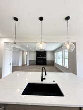 Kitchen featuring open floor plan, light stone countertops, a textured ceiling, and a sink