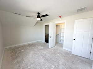 Unfurnished bedroom with visible vents, vaulted ceiling, and baseboards