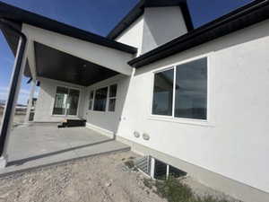 Rear view of house featuring stucco siding and a patio area