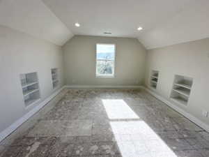 Additional living space with lofted ceiling, baseboards, recessed lighting, and built in shelves