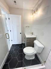 Bathroom featuring visible vents, toilet, tile patterned flooring, and a sink