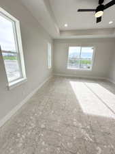 Unfurnished room with a raised ceiling and baseboards