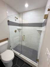 Full bath with toilet, recessed lighting, a shower stall, and tile patterned floors
