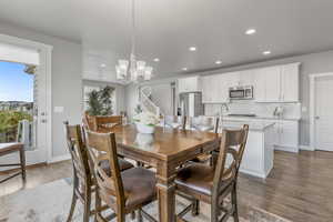 Dining space with recessed lighting, wood finished floors, baseboards, and an inviting chandelier