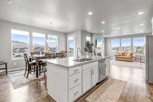 Kitchen featuring hardwood / wood-style floors, a sink, a notable chandelier, and appliances with stainless steel finishes