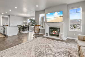 Living area featuring wood-type flooring, a glass covered fireplace, baseboards, and recessed lighting