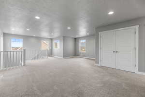 Spare room featuring carpet, a textured ceiling, and recessed lighting