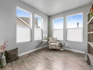Living area featuring baseboards, wood finished floors, and recessed lighting