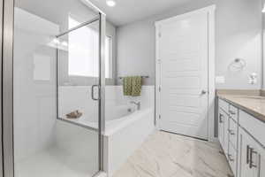 Full bathroom featuring recessed lighting, marble finish floor, a shower stall, a garden tub, and vanity