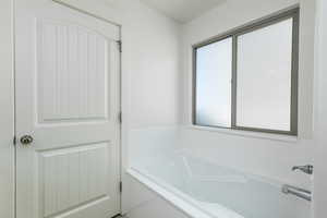 Bathroom featuring a healthy amount of sunlight and a garden tub
