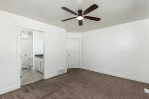 Unfurnished bedroom with visible vents, ensuite bathroom, baseboards, and light carpet