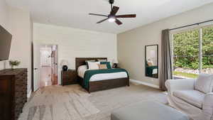 Carpeted bedroom with ensuite bath and ceiling fan