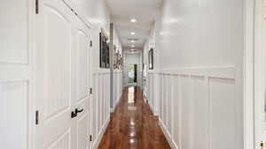 Hall featuring dark wood-style floors and recessed lighting