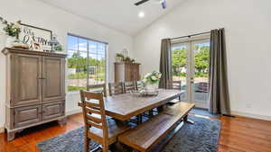 Dining area with high vaulted ceiling, a ceiling fan, wood finished floors, and recessed lighting