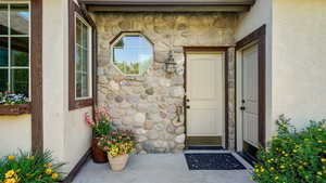 View of exterior entry featuring stone siding and stucco siding