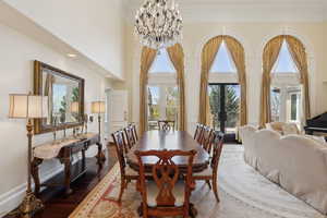 Dining area featuring a chandelier, wood finished floors, a high ceiling, and recessed lighting