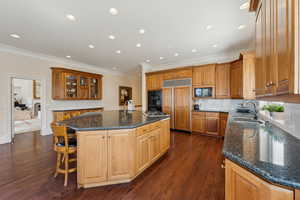 Kitchen featuring black appliances, dark wood-style flooring, crown molding, and a sink
