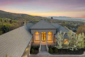 View of front of home with stucco siding, a chimney, stairway, and a mountain view