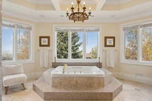 Full bath featuring a bath, ornamental molding, a chandelier, and coffered ceiling